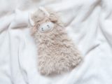 A charming fluffy yak resting on a luxurious white soft blanket, ready for a product photoshoot.