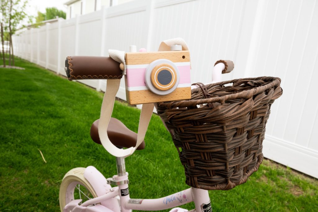 Wooden Camera Toy on Pink Bike Handlebars